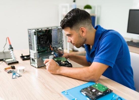 Técnico realizando manutenção em um computador na bancada
